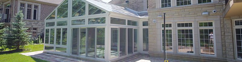Four season sun room in Michigan installed with glass door walls and glass windows, for a glass wall & abundant sunlight